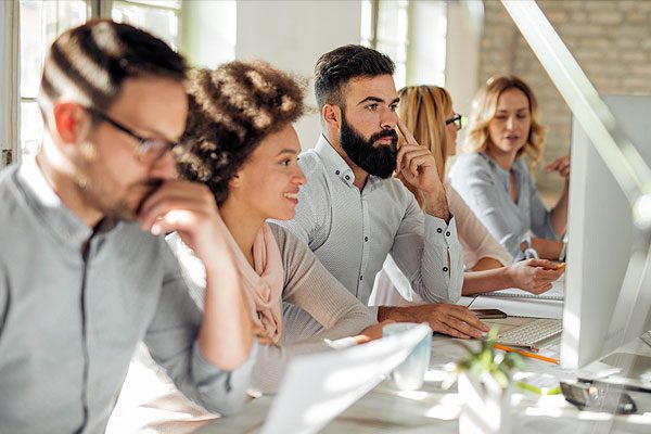 Cinque professionisti uomini e donne lavorano insieme al computer