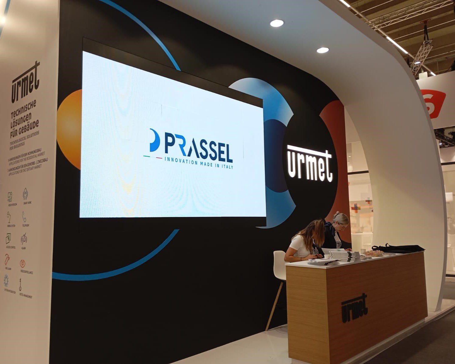 Reception dello stand Urmet alla fiera internazionale Light + Building con logo Prassel su un ledwall